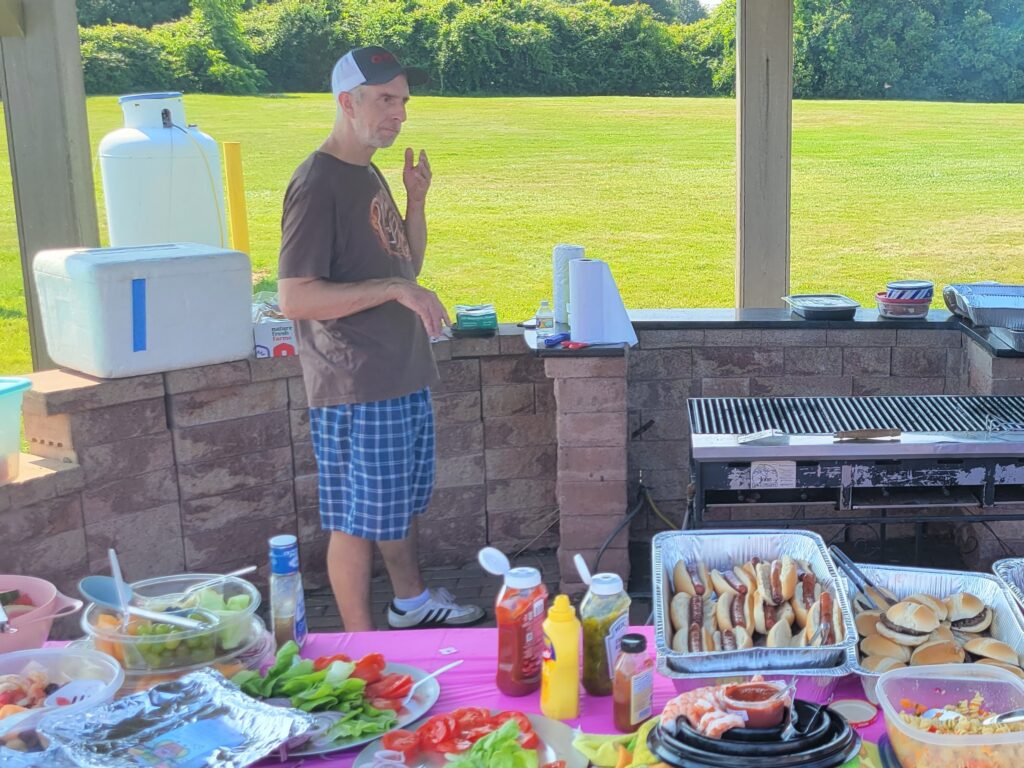 Chris serves up the burgers and dogs.